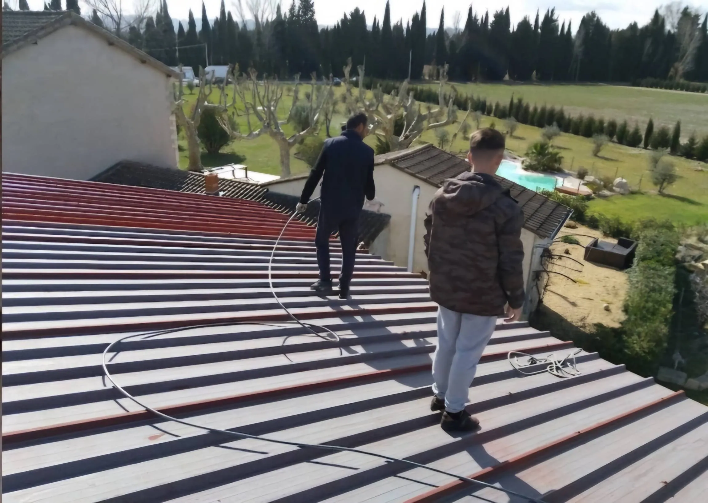 Deux couvreurs posant des tuiles sur un toit à Tarascon
